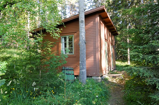 Valla 6:43. Byggnad i orange panel, fönster med gröna spröjs och gröna portar.