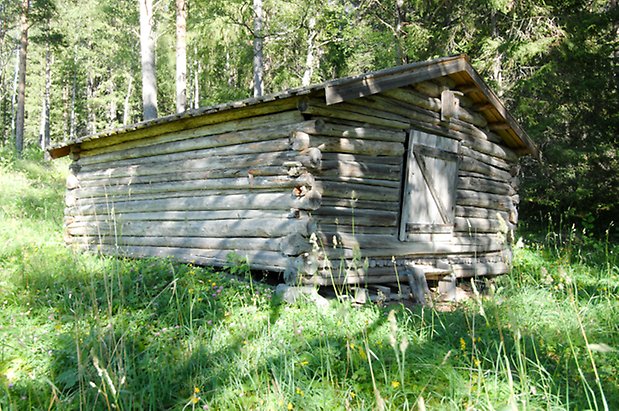 Valla 6:43. Byggnad i grått timmer med grå lucka.