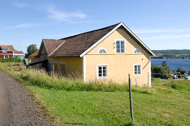 Valla 8:20. Ladugård i gul puts med vita detaljer i två våningar. Fönster med vita spröjs, fyra beige dubbelportar.