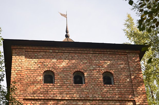 Elektricitetsbyggnad - Torn i tegel, inzoomad bild på fönstergluggar där takets spira med metallflagga syns.