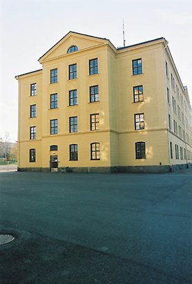 Fältjägaren 3 - Stor gul byggnad i fem våningar med svart tak sett från sidan.