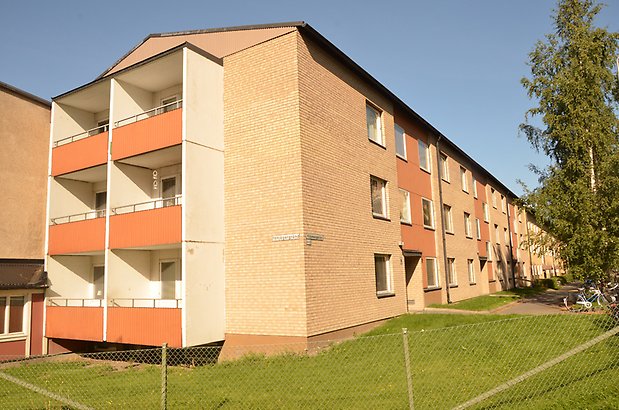 Garvaren 4. Tegelhus i tre våningar med orangea balkonger.