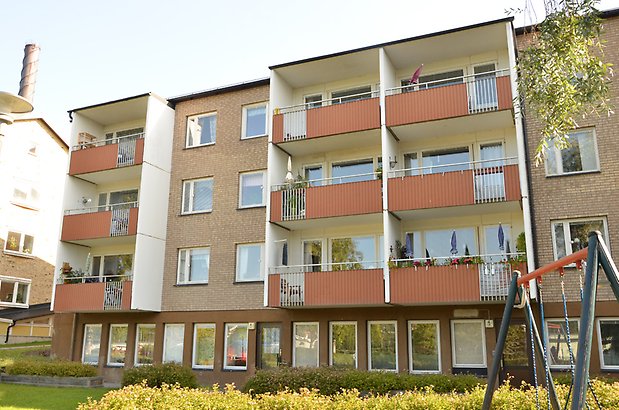 Garvaren 4. Tegelhus i tre våningar med orangea balkonger.