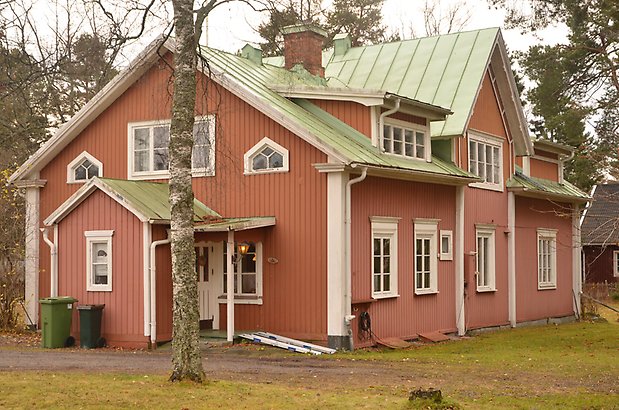 Urd 4. Villa med rosa träpanel, vita fönster med spröjs och grönt plåttak.