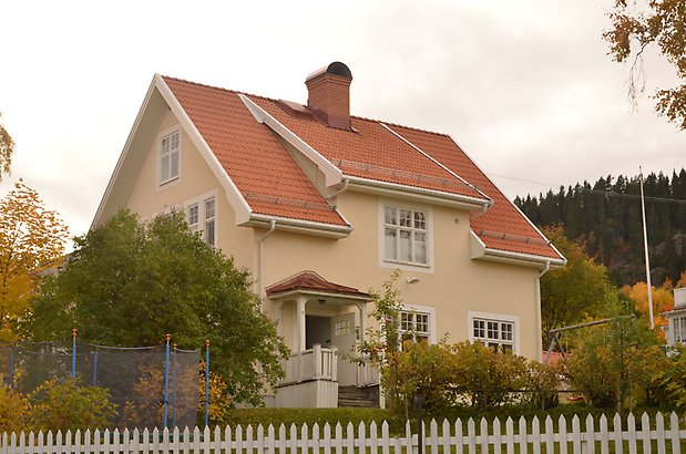 Bokhållaren 12. Villa i ljusgul puts med vita fönster med spröjs och rött tegeltak.