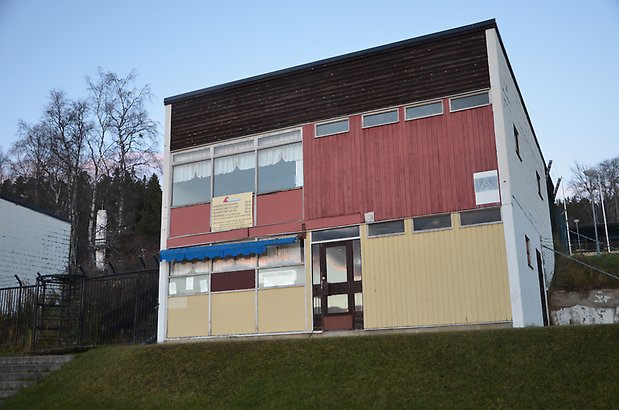 Frösö Berge 21-212. Byggnad med gul, röd och brun panel, glas port och fönster.