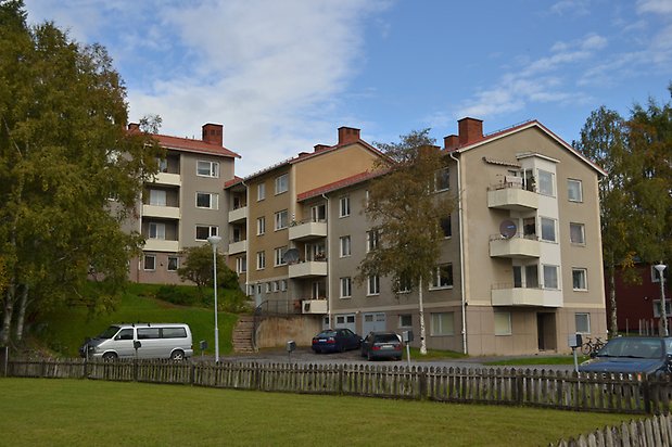 Gubbåkern 13. Bostadshus i fyra våningar i beige puts med vita balkonger och vita fönster.