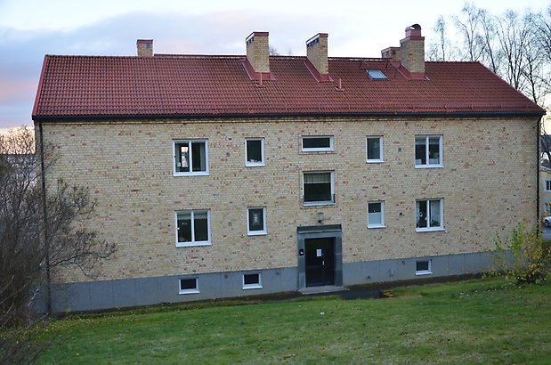 Majoren 5. Bostadshus i tre våningar i gult tegel och vita fönster och brun port.