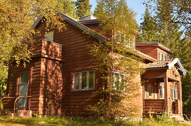 Sandtaget 1. Villa i brun, liggande fasad och vita fönster.