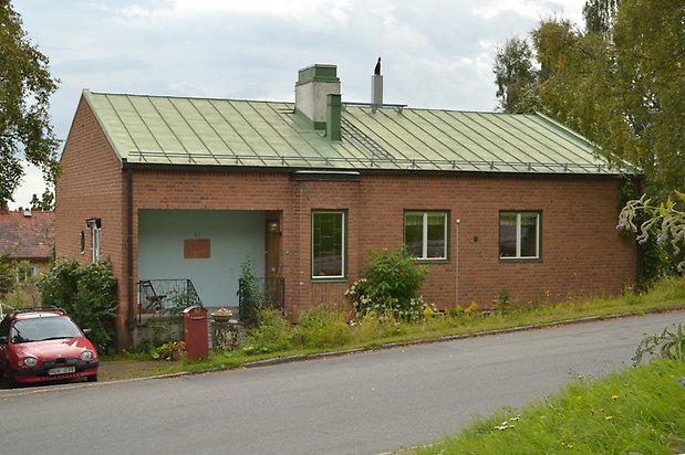 Åkermannen 9. Villa i brunt tegel med gröna fönster och grönt plåttak.