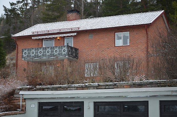 Berghem 6. Villa i brunt tegel med vita fönster och balkong med smidesutsmyckningar. 