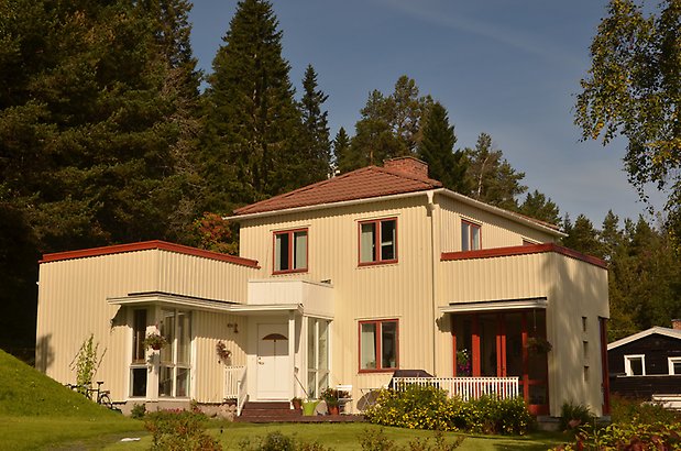 Frostmannen 5. Villa i ljusgul panel med röda fönster.