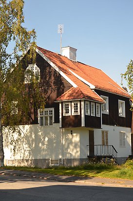 Fritzhem 2. Villa med brun panel på övervåningen och vit puts på nedervåningen, vita fönster och ett burspråk på övervåningen. 