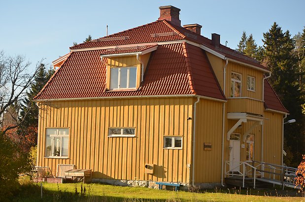 Frösö Berge 9-19. Villa i gul panel med vita fönster, liten balkong och rött tegeltak med takkupor.