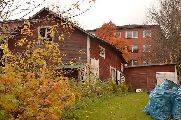 Muraren 7-1. Byggnad i röd, liggande panel med vita dörrar.