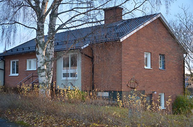 Stråken 6. Villa i brunt tegel med vita fönster och svart tegeltak. 