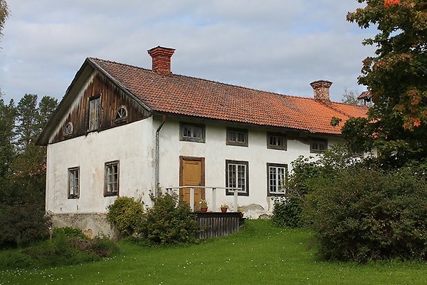 Brunflo-Änge 1:118. Byggnad i vit puts med bruna fönster med spröjs och gula dubbeldörrar.