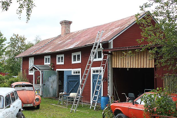 Brunflo-Änge 1:24. Byggnad i röd, liggande panel med vita fönster med spröjs och blå dörrar.