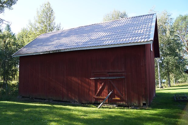 Ope 5:39. Byggnad i röd panel med röd dubbelport.