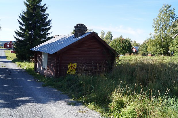 Torvalla  3:4 Timrad, brun byggnad med vit lucka och skorsten.