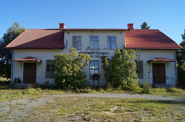 Brunflo Prästbord 1:12. Byggnad i två våningar i ljus puts, två dubbeldörrar, på fasaden står det: "Löfbergets folkskola"