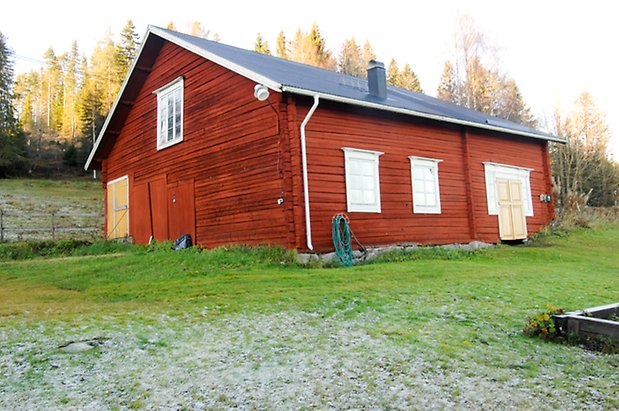 Lockne-Berge 2:2. Ladugård i rött timmer i två våningar, vita fönster med spröjs och en gul dubbeldörr, en gul dubbelport och röda luckor. 