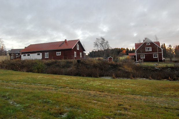 Börön 8:2. Ladugård i röd panel och vit puts och villa i röd panel och vita detaljer.