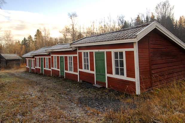 Lockne Prästbord 1:2. Kyrkstall i röd liggande panel med gröna dörrar.