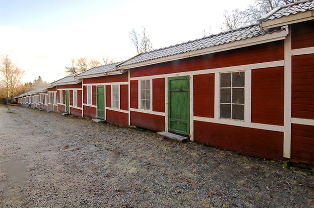 Lockne Prästbord 1:2. Kyrkstallar i röd, liggande panel, gröna dörrar med fönster med vita spröjs.