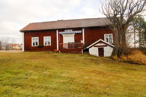 Ångsta 2:2. Hus i röd panel med vita dubbeldörrar och fönster med vita spröjs, med jordkällare.