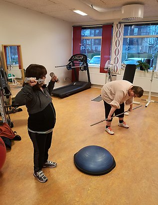 Två personer tränar i en träningslokal