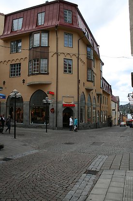 Stenbyggnad i tre våningar i mörkgul puts. Första våning i grå sten. Svarta fönsterfoder, vita fönster med många rutor med spröjs. Burspråk klädda i mörk trä. Rött plåttak.