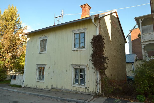 Mården 4 - Hus i beige puts med ljusgröna fönster och balkong med ljusgrönt staket.