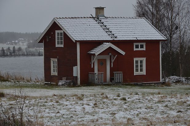 Valla 6:1. Villa med röd liggande panel, vita fönster med spröjs, gul dörr och rött tegeltak. 