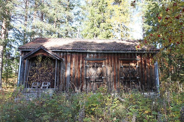 Valla 8:15. Hus, omålad, åldrad panel. Utsmyckade fönsterluckor och förstukvist.