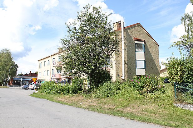 Bergsvik 9. Flerbostadshus i gult tegel i tre våningar med rosa balkonger.