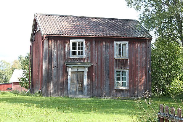 Söre 2:159. hus i röd panel med vita fönster med spröjs och dubbeldörr i trä.