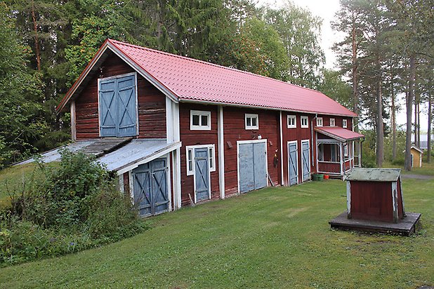 Söre 2:35. Byggnad i röd panel med blå dörrar med kryss på och vita fönster.