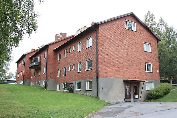 Söre 2:100. Flerbostadshus i brunt tegel med bottenvåning i betong.