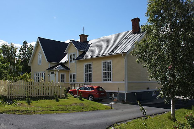 Orrviken 6:8. Villa i gul, liggande panel med vita fönster med spröjs.