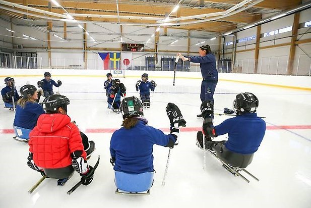 Hockeylirare lyssnar på tränaren