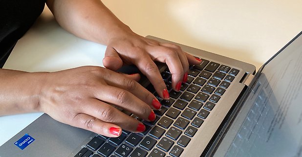 Ett par händer skriver på en dator