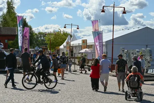 Krogstråket entré en solig dag. Mycket människor framför.