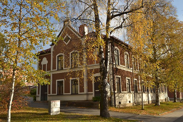 Stenbyggnad i två våningar i brun puts med vita detaljer. Bruna fönster med spröjs. Taket är smyckat med ett vitt kors.