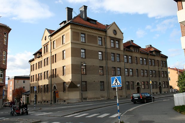 Stenbyggnad i fem våningar, randigt i ljusbrun och brun puts. Tegeltak. Bruna fönster med spröjs. Takkupor.