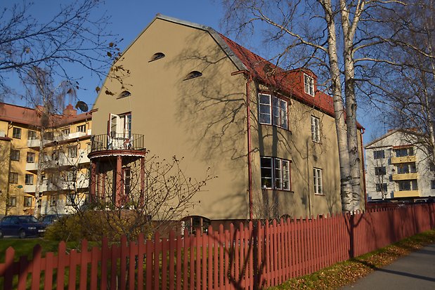 Sten byggnad i grön puts i tre våningar. Rött plåttak med takkupa, vita fönster med spröjs. Balkong på kortsidan med röda pelare under. Burspråk på långsidan.