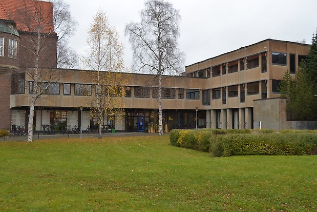 Byggnad i två våningar i beige puts. Svarta fönster i olika storlek, utan spröjs. Glaspartier på markplan. Platt tak.