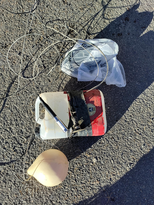 Bilden visar en tom plastdunk, en boj, en vajer med en mätare fäst i slutet