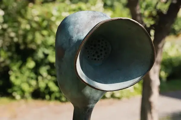 En metallskulptur mitt i en park.